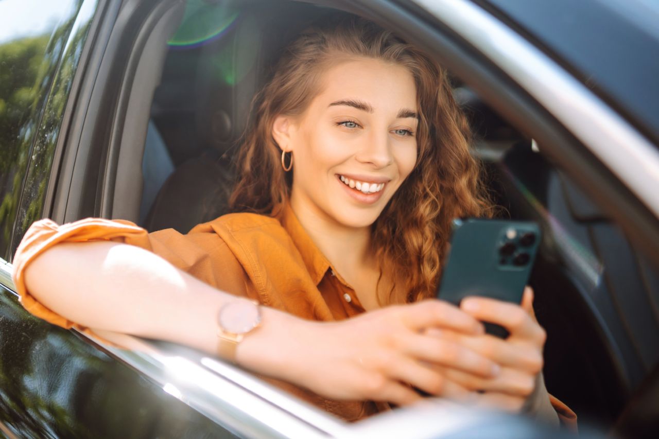 em_pasin_woman_city_cars_smartphone_happy_groceries_bag_photogr_741bc280-b5ed-4923-a7cc-7e158d657d78 1